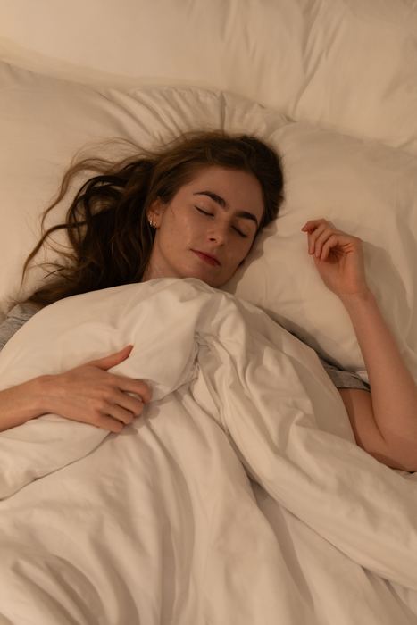 Winks studio photograph of a woman resting in bed
