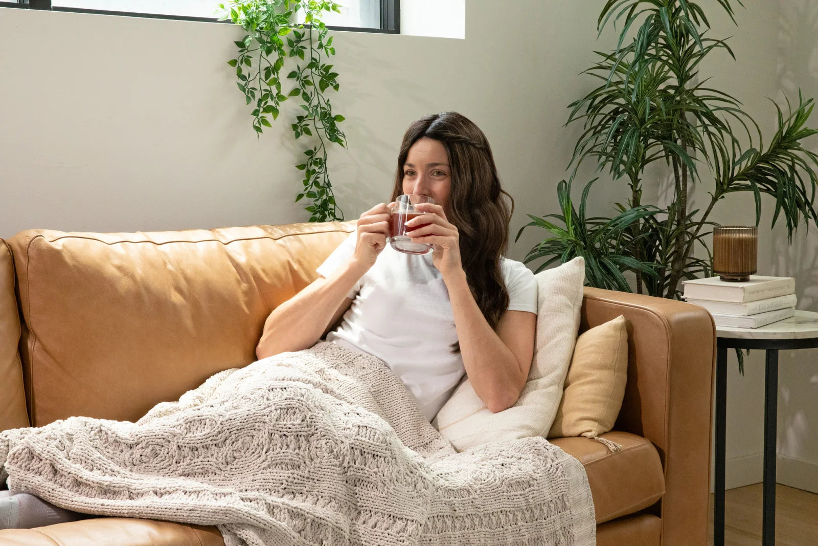 An adult sitting on a couch with a Winks drink