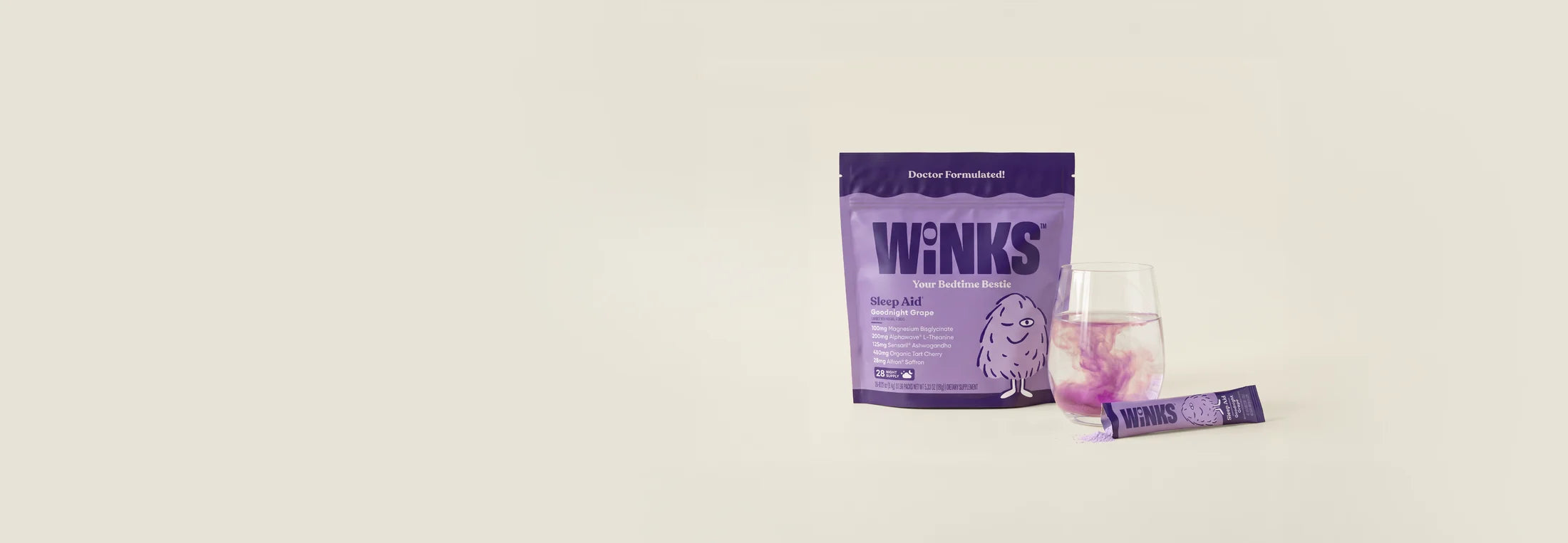 Winks pouch and stick beside a glass of prepared drink