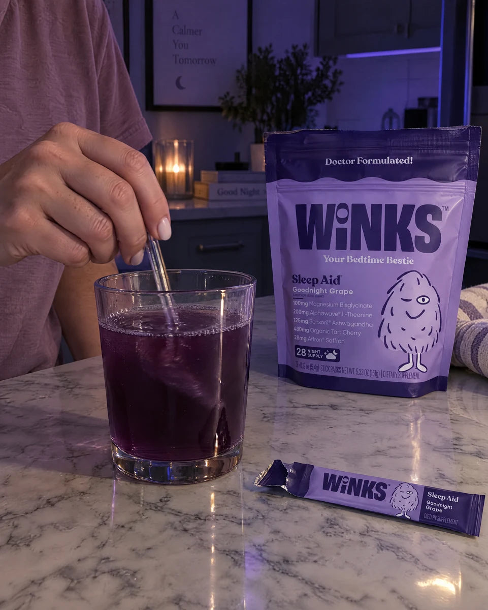 Hands stirring a prepared Winks drink beside the pouch.