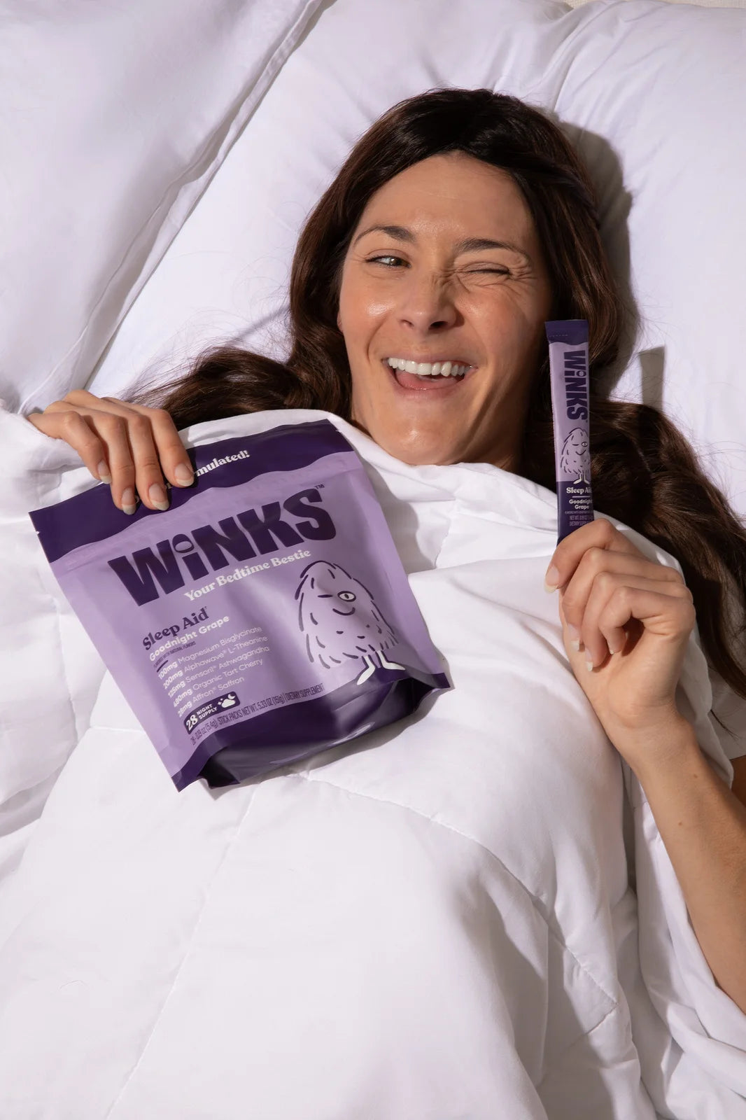 Adult sitting on a bed holding Winks
