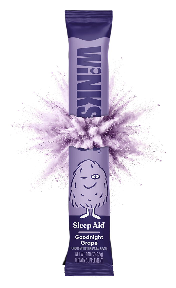 A Winks Goodnight Grape stick pack torn in two along one shared tear, with lavender powder bursting out between the halves.