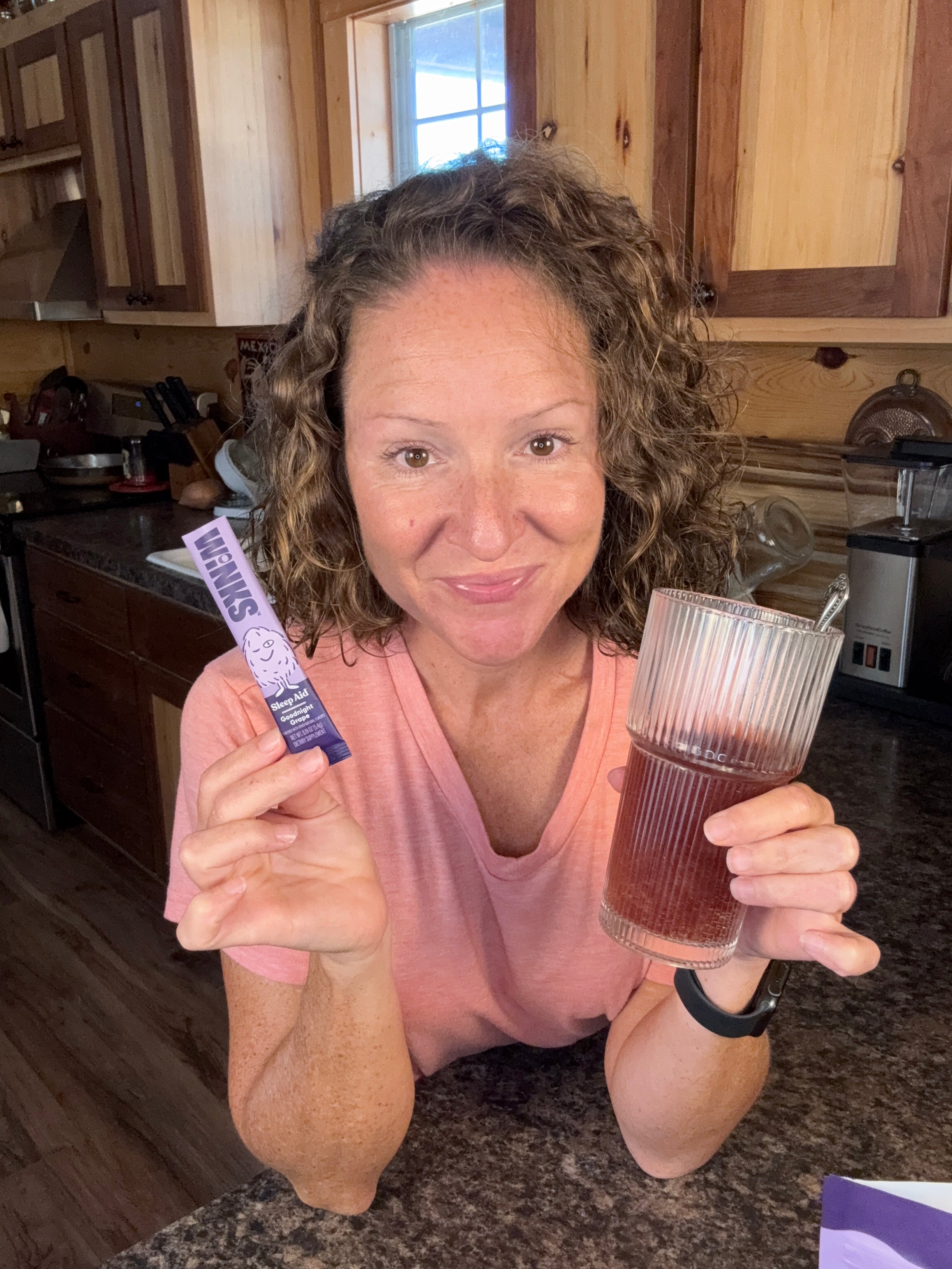 Heather holding a prepared drink and a Winks stick pack